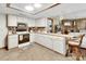 Open kitchen with white cabinets and a breakfast bar overlooking the living room and fireplace at 5967 Plantera Ct, Port Orange, FL 32127