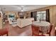 Spacious living room with a brick fireplace, wood-paneled walls, and sliding glass doors to the lanai at 5967 Plantera Ct, Port Orange, FL 32127