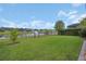 Expansive backyard with lush lawn, lake view, and black metal fence at 6254 Woodhaven Village Dr, Port Orange, FL 32128