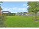 Lush green backyard with fencing overlooking the serene lake at 6254 Woodhaven Village Dr, Port Orange, FL 32128