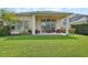 Lush green backyard with a covered patio, perfect for outdoor living and entertaining at 6254 Woodhaven Village Dr, Port Orange, FL 32128
