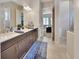 Bathroom showcasing double sink vanity with stone countertops and tiled floors leading to the bedroom at 6254 Woodhaven Village Dr, Port Orange, FL 32128