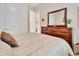 Bedroom featuring a dresser, large mirror, and a bed with soft, neutral bedding at 6254 Woodhaven Village Dr, Port Orange, FL 32128