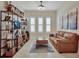 Cozy living room with hardwood floors, plantation shutters, a plush sofa, and media center at 6254 Woodhaven Village Dr, Port Orange, FL 32128