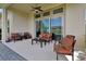 Covered outdoor patio area featuring comfortable seating, ceiling fan, and sliding glass doors at 6254 Woodhaven Village Dr, Port Orange, FL 32128