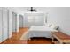 Bedroom featuring wood floors, ceiling fan, plantation shutters, and ample natural light at 701 N Tuxedo Ave, Deland, FL 32724