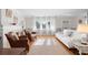 Bright living room with hardwood floors, white sofa, and large windows at 701 N Tuxedo Ave, Deland, FL 32724