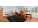 Spacious living room featuring a brick fireplace, wood-look floors, and plantation shutters at 701 N Tuxedo Ave, Deland, FL 32724
