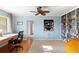 Home office with blue paneled walls, built-in bookcase, ceiling fan, and natural light at 701 N Tuxedo Ave, Deland, FL 32724