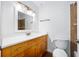 Bright bathroom featuring a wooden vanity, white countertop, framed mirror, and a standard toilet at 718 Sleepy Hollow Dr, Port Orange, FL 32127