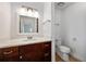 Bathroom featuring a dark wood vanity, white countertop, framed mirror, and a standard toilet at 718 Sleepy Hollow Dr, Port Orange, FL 32127