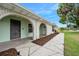 Exterior shot showcasing the front door and brick archway, complemented by a neatly kept lawn and mulched flowerbeds at 718 Sleepy Hollow Dr, Port Orange, FL 32127