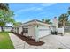 View of the home with an attached two-car garage, and long driveway and mature landscaping at 718 Sleepy Hollow Dr, Port Orange, FL 32127