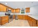 Kitchen featuring tile floors, stainless steel appliances, and wooden cabinets at 718 Sleepy Hollow Dr, Port Orange, FL 32127