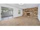 Cozy living room showcasing a stone fireplace, plush carpeting, and an adjacent sunroom at 718 Sleepy Hollow Dr, Port Orange, FL 32127