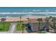 Beach home with private access to the sandy beach and ocean, complemented by palm trees at 8 Ocean Dunes Dr, Ormond Beach, FL 32176