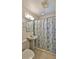Bathroom with a pedestal sink, toilet, and a shower with seashell-themed curtains at 8 Ocean Dunes Dr, Ormond Beach, FL 32176