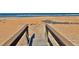 Private beach access via a wooden walkway, offering a seamless transition to the sandy shores at 8 Ocean Dunes Dr, Ormond Beach, FL 32176