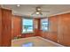 A bright bedroom has wood paneling, a ceiling fan, and a beach view from its large window at 8 Ocean Dunes Dr, Ormond Beach, FL 32176