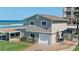 Beach home with a two-car garage, brick-paved driveway, manicured grass, and a covered outdoor bar area at 8 Ocean Dunes Dr, Ormond Beach, FL 32176