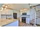 Modern kitchen with marble countertops, white cabinets, black appliances, and a unique spiral staircase to the upper level at 8 Ocean Dunes Dr, Ormond Beach, FL 32176