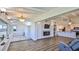 Open living room and kitchen with hardwood floors, brick fireplace, ocean view, and white trim at 8 Ocean Dunes Dr, Ormond Beach, FL 32176