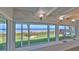 Living room with large windows showcasing ocean views, hardwood floors, modern decor, and a brick outdoor fireplace at 8 Ocean Dunes Dr, Ormond Beach, FL 32176