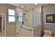Bathroom featuring a glass shower enclosure, shower head, window and white tile surround at 8 Ocean Dunes Dr, Ormond Beach, FL 32176
