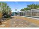 Backyard with paver and gravel walkway, lush landscaping, and screen enclosed pool at 809 E 14Th Ave, New Smyrna Beach, FL 32169