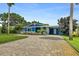 Exterior of a charming blue home with a brick driveway and well-kept landscaping at 809 E 14Th Ave, New Smyrna Beach, FL 32169