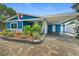 Beautiful blue home featuring a brick driveway, covered parking, and manicured landscaping at 809 E 14Th Ave, New Smyrna Beach, FL 32169