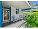 Charming front porch featuring painted brickwork, seating, and a glass front door at 809 E 14Th Ave, New Smyrna Beach, FL 32169