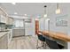 Bright kitchen with modern lighting, gray cabinets, stainless steel appliances and an island with chairs at 809 E 14Th Ave, New Smyrna Beach, FL 32169