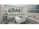 Cozy living room with a view of the backyard, comfortable seating, and a glass coffee table with a large window at 809 E 14Th Ave, New Smyrna Beach, FL 32169