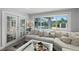 Bright living room with a large window view to the screened pool and light-colored sectional sofa at 809 E 14Th Ave, New Smyrna Beach, FL 32169