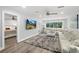 Light-filled living room with neutral walls, ceiling fan, large windows, and an adjacent bedroom at 809 E 14Th Ave, New Smyrna Beach, FL 32169