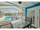 Screened in pool with seating and table, with access door to the main house at 809 E 14Th Ave, New Smyrna Beach, FL 32169