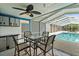 Screened pool with outdoor dining area featuring a ceiling fan and summer kitchen at 809 E 14Th Ave, New Smyrna Beach, FL 32169