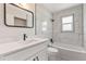 Bright bathroom features a modern vanity and a shower-over-tub setup with elegant white marble-look tile at 825 Wells Dr, South Daytona, FL 32119