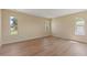 Sunlit bedroom with hardwood floors and views of surrounding neighborhood at 825 Wells Dr, South Daytona, FL 32119