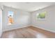 Bedroom with wood-look flooring and white walls, illuminated by natural light from two windows at 825 Wells Dr, South Daytona, FL 32119