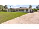 Charming single-story home with a well-manicured lawn and a long concrete driveway at 825 Wells Dr, South Daytona, FL 32119