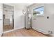 This laundry room boasts wood floors and a window providing natural light, next to a water heater at 825 Wells Dr, South Daytona, FL 32119
