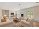 Bright living room featuring a white-painted brick fireplace and neutral-toned furniture at 825 Wells Dr, South Daytona, FL 32119