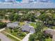 Aerial view of the home displaying the manicured lawn, mature landscaping, and the long driveway leading to the property at 832 Wildwood Cir, Port Orange, FL 32127
