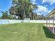Green grass and a white fence enclose a large backyard with a storage shed at 832 Wildwood Cir, Port Orange, FL 32127