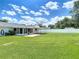A wide backyard view shows a white fence, screened-in patio and a well-manicured lawn at 832 Wildwood Cir, Port Orange, FL 32127
