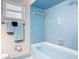 Blue tiled bathroom featuring a bathtub, shower, and a window with natural light at 832 Wildwood Cir, Port Orange, FL 32127
