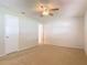 Carpeted bedroom featuring a ceiling fan and white doors adding simplicity to the space at 832 Wildwood Cir, Port Orange, FL 32127