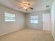 Carpeted bedroom with neutral walls, ceiling fan and two windows offering lots of natural light at 832 Wildwood Cir, Port Orange, FL 32127